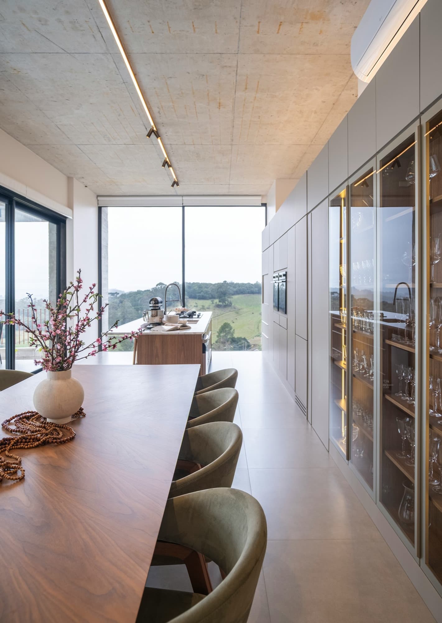 Dining room with olive velvet chairs and linear track lighting