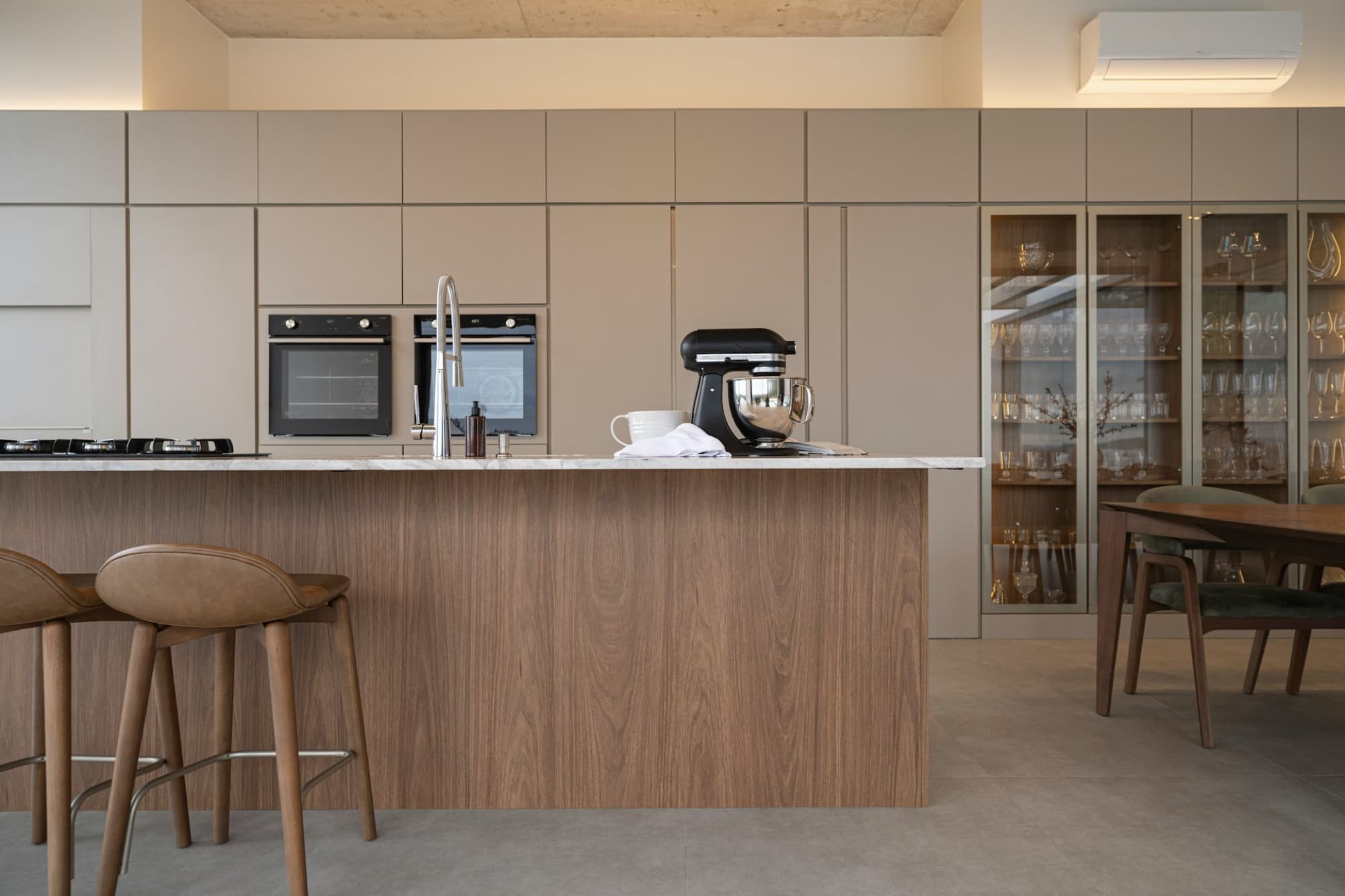 Warm oak kitchen with bronze-framed glass cabinetry