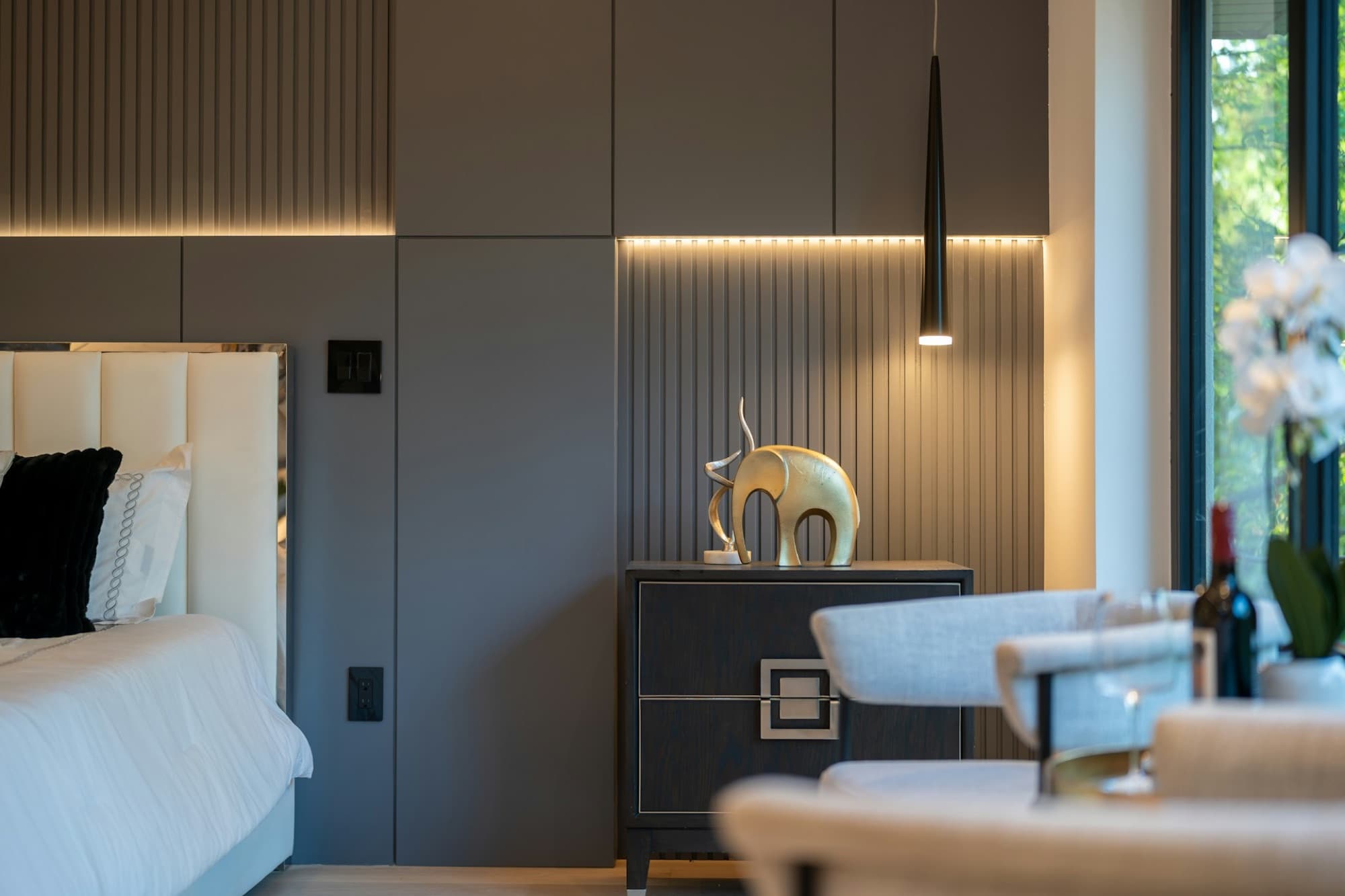 Bedroom wrapped in smoked oak panelling with a hidden light line