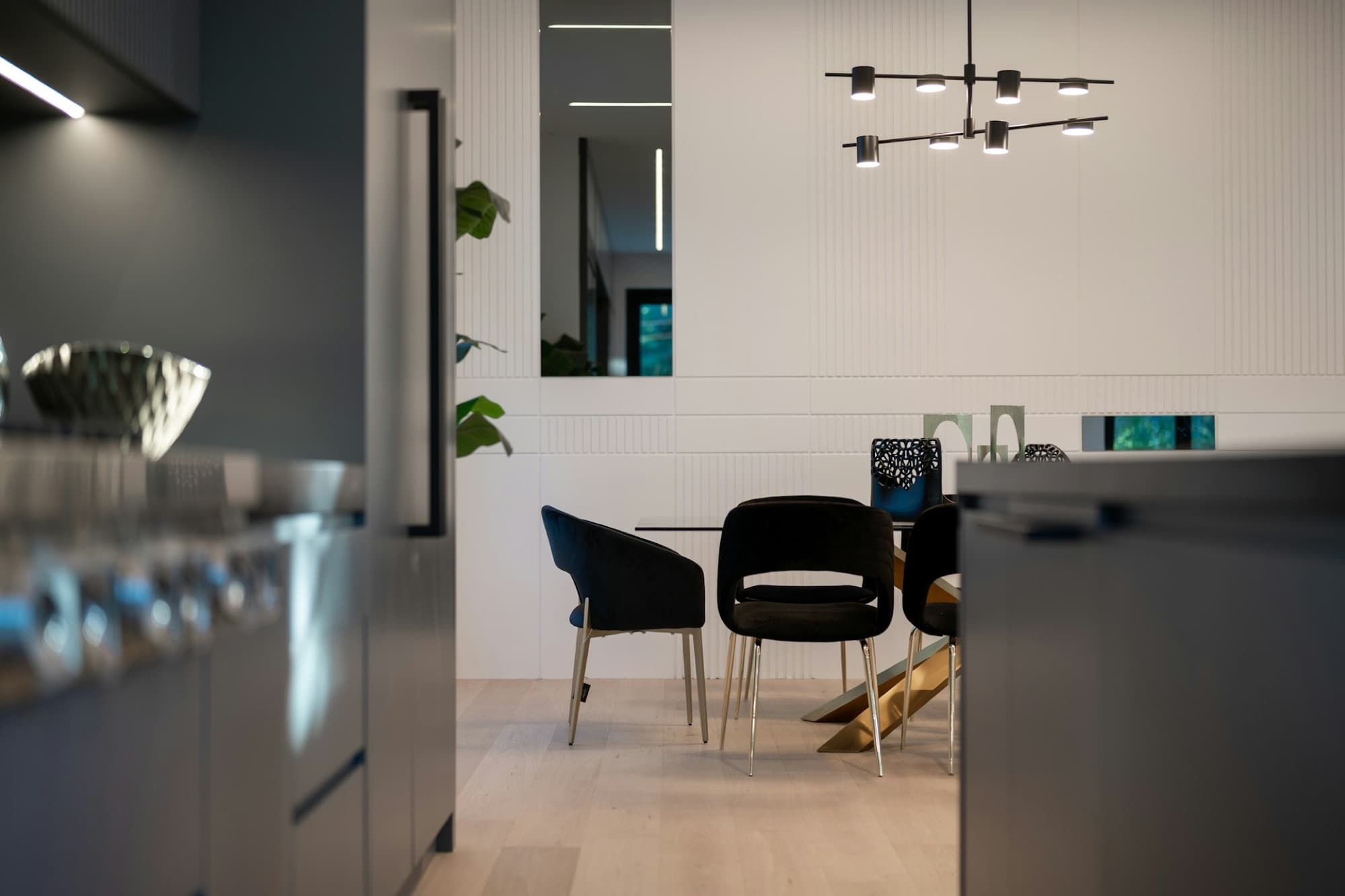 Dining area with sculptural pendant and black leather chairs